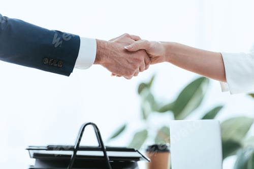 Preview: selective focus of woman and man shaking hands at office