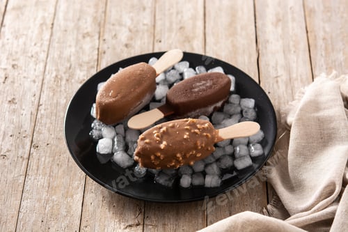 Preview: Chocolate popsicles and crushed ice on black plate