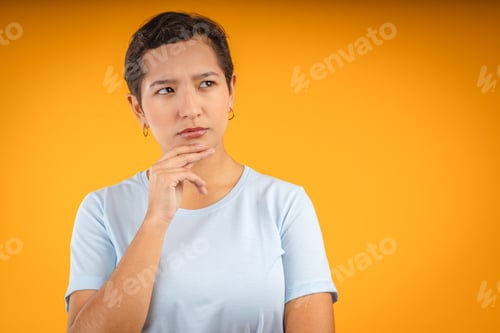 Vista previa: Young woman deep in thought on yellow background