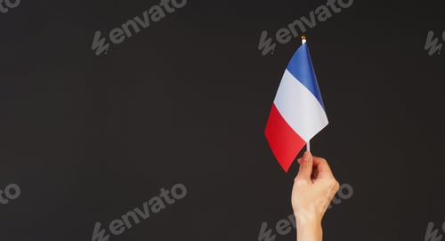 Preview: Hand is hold french flag on black background