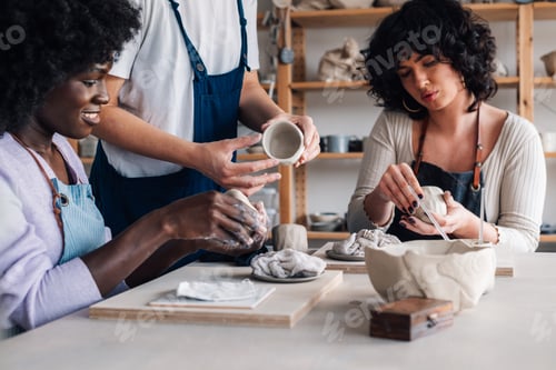 Preview: Interracial pottery class students with clay in hands learning clay work