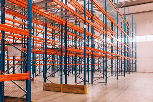 Preview: Empty Industrial Warehouse with Colorful Storage Racks and Open Space