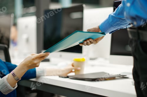 Preview: Two managers exchange documents in IT office