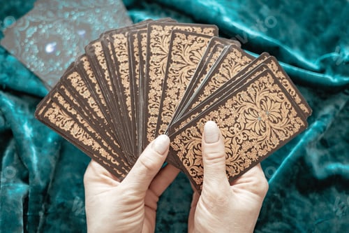 Preview: tarot cards and runes in the hands of a girl on a blue velvet background