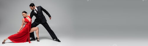 Preview: Stylish man in suit performing tango with woman on grey background, banner