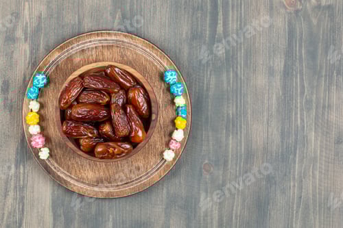 Preview: Bowl of dates and popcorns on wooden plate