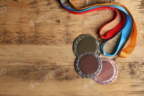 Preview: Gold, silver and bronze medals on wooden background, flat lay. Space for design
