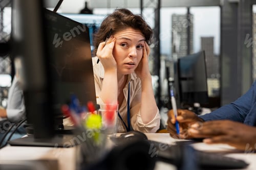 Preview: Concerned woman working with a colleague in a stressful situation