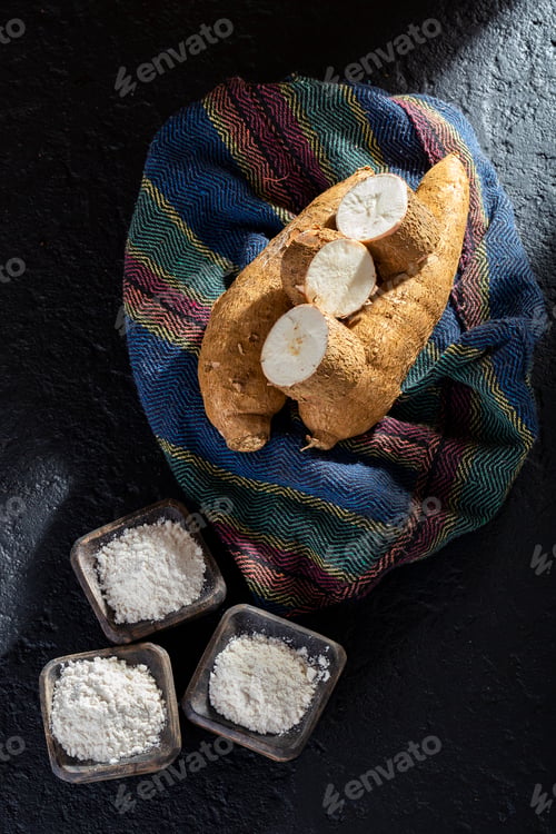 Preview: pile of cassava and cassava flour on dark background (Manihot esculenta)