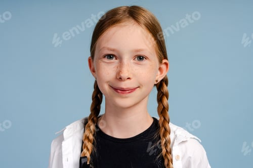 Preview: Portrait of smiling redhead girl with braids on blue background