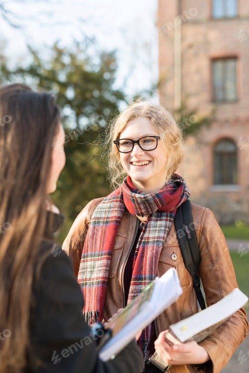 Preview: Smiling teenage girl with female friend in college campus