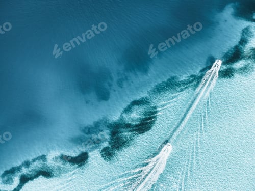 Preview: Aerial top shot of a boat leaving trail on clear seawater