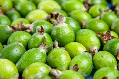 Preview: Side view of fresh natural green feijoas small vitamin bomb on blue background