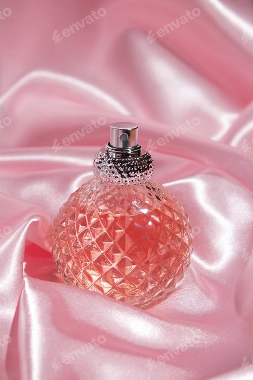 Preview: Perfume bottle on silk. Concept of expensive perfume and cosmetics.