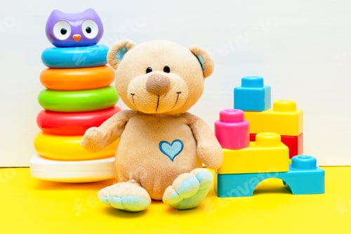 Preview: teddy bear with colorful pyramid, constructor, toy blocks for children play white yellow background