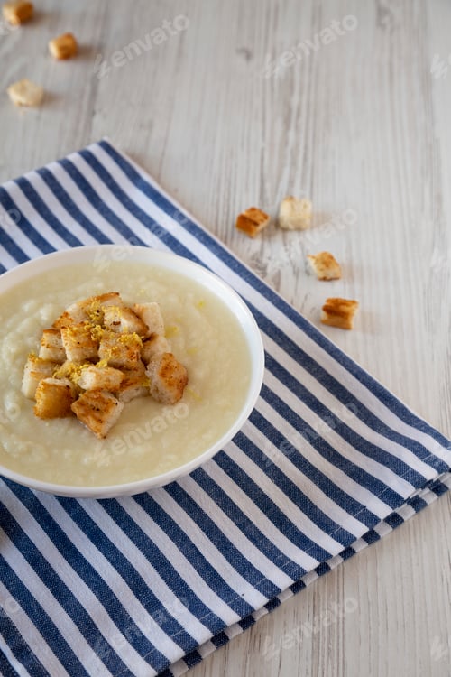 Preview: Homemade Cauliflower Soup with Croutons and Oil, side view. Space for text.