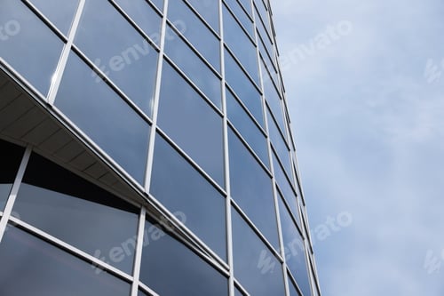 Preview: Modern building with tinted windows against sky, low angle view. Urban architecture