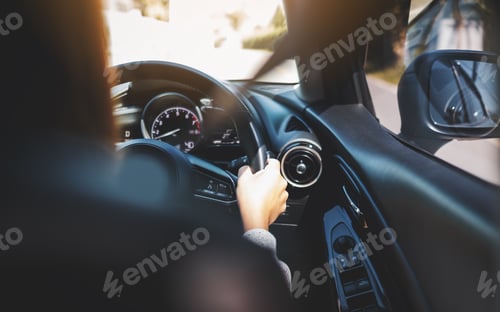 Preview: Closeup image of a woman holding steering wheel while driving a car on the road