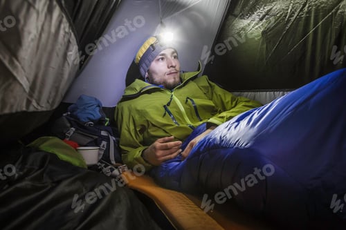 Preview: Young male hiker in tent on Klammspitze mountain, Oberammergau, Bavaria, Germany