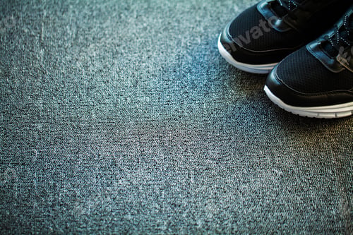 Preview: Pair of new stylish black sneakers on floor at home