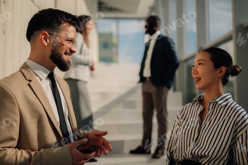 Preview: Business people talking during informal meeting in office hallway