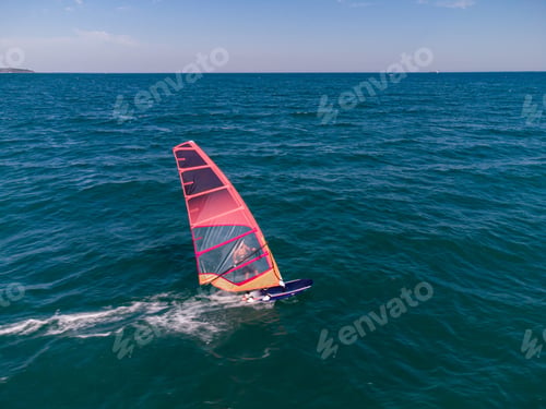 Preview: skiing windsurfing in the sea at sunset