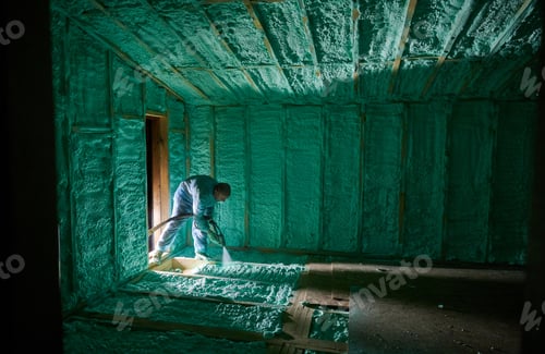 Preview: Worker spraying polyurethane foam for insulating wooden frame house.