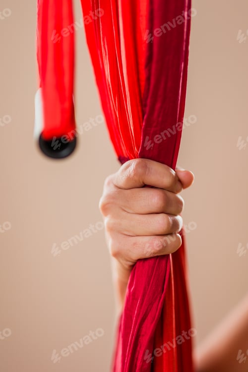 Preview: Hand gripping red aerial yoga hammock fabric