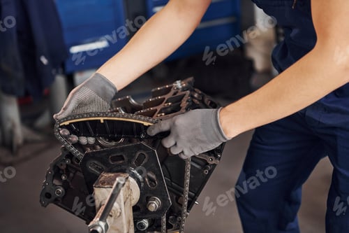 Preview: Close up view of professional repairman in garage that works with broken automobile engine