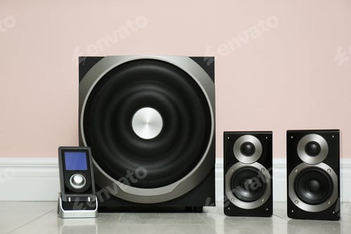 Preview: Modern powerful audio speaker system on floor near pink wall