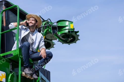Preview: Farmers sit on a sugarcane harvester.