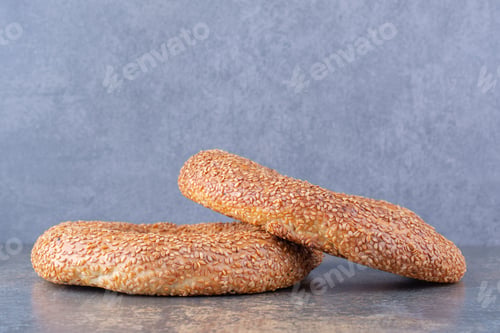 Preview: Two sesame coated, crisp bagels on marble background