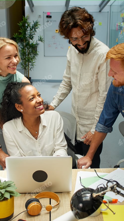 Preview: Vertical. Group of professional multirracial men and women working at office. Colleagues look happy.
