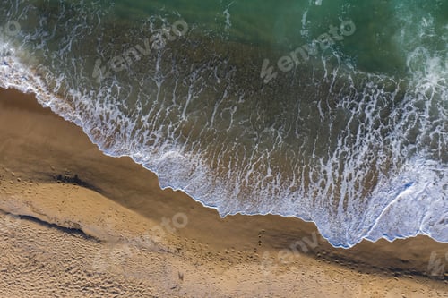 Preview: Aerial view of ocean waves washing a sandy shoreline