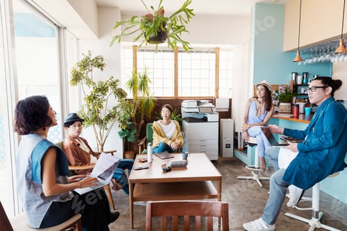 Preview: Group of young Japanese professionals working on laptop computers in a co-working space.