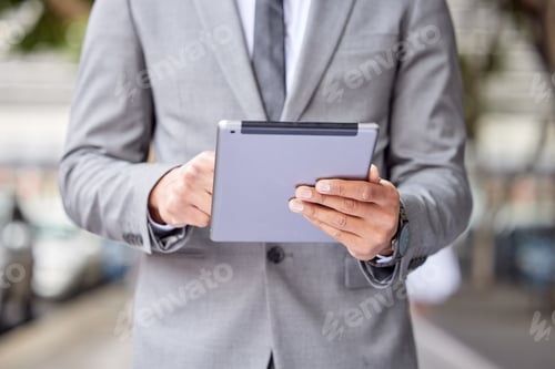 Preview: Cropped shot of an unrecognizable businessman standing and using a digital tablet in the city