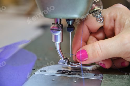 Preview: Close up of a tailor hand threading sewing machine.