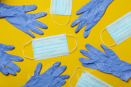 Preview: Medical gloves and masks on yellow background, top view