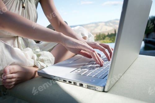 Preview: Close up of woman using laptop outdoors