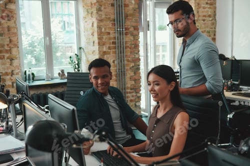 Preview: Daily routine. Group of young employees working on computers and discussing project results while