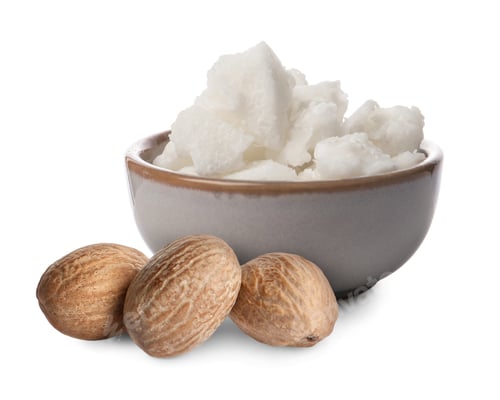Preview: Natural shea butter in bowl and nuts isolated on white