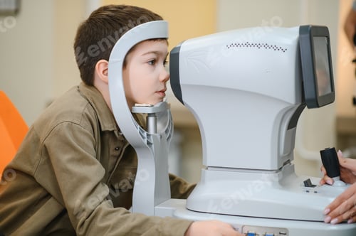 Preview: Boy undergoing eyesight examination with autorefractor in ophthalmology clinic