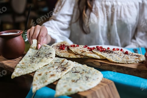Preview: man are taking mixed kutab from the wooden board greens meat side view