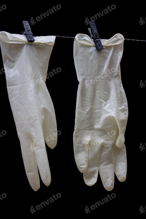 Preview: Vertical closeup shot of white plastic gloves hanging on a rope