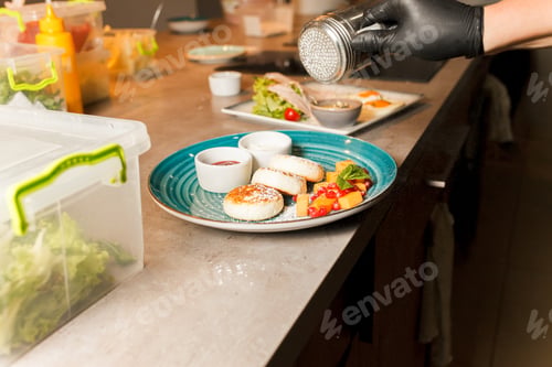 Preview: Restaurant’s cook has prepared delicious cheese pancakes and sprinkles them with powder