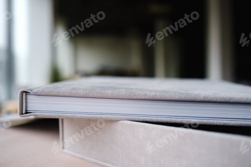 Preview: A photo book in a grey cloth cover lies on the box. the concept of creating books and albums