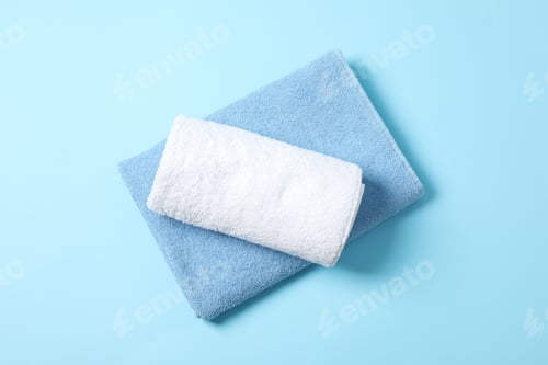 Preview: Folded towels on blue background, top view and space for text