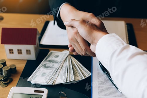 Preview: Business Handshake with House and Money on Desk