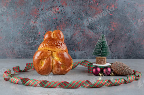 Preview: Circle of colorful ribbon around a sweet bun and christmas decorations on marble background