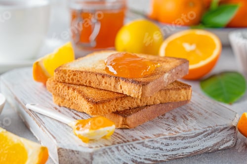 Preview: Bread toasts with homemade orange jam on a white plate on a gray concrete background